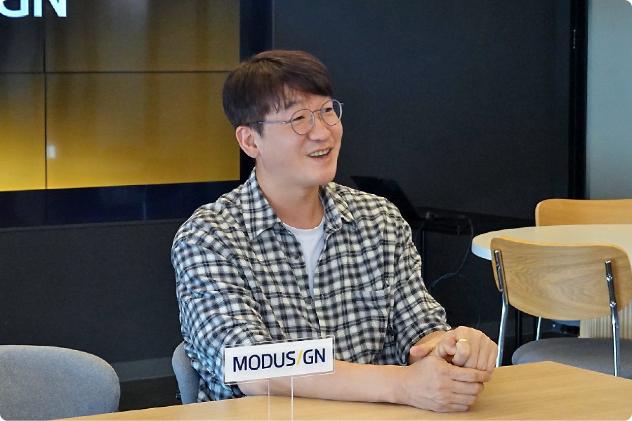 모두싸인 김진범 CISO가 인터뷰 테이블에 앉아 미소 지으며 이야기하는 모습